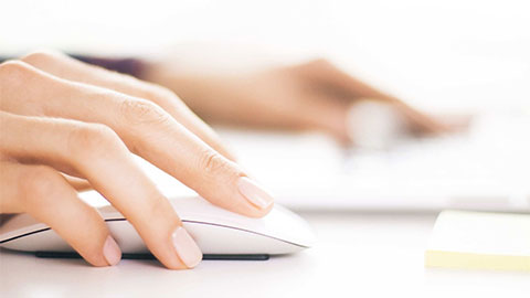 Closeup of woman hands using computer mouse.