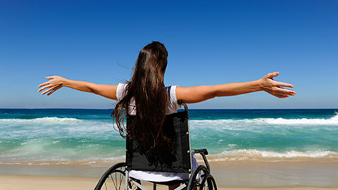 Woman in wheelchair on the beach.