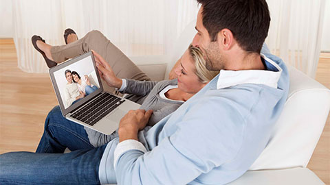 Loving couple using laptop.