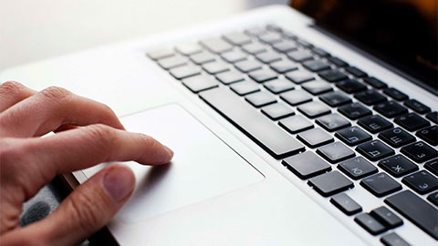 Close up of hand using a keyboard.
