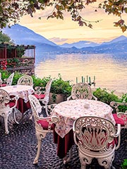 Waterfront tables at Lake Como overlooking the Alps at sunset ©Xantana.