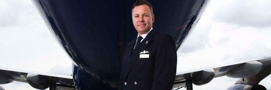 Captain Steve Allright in uniform standing under an aircraft.
